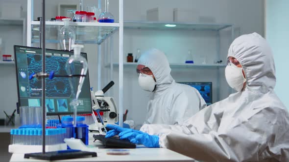 Scientists in Protection Suits Working in Chemical Lab