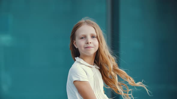 Close Up of Lonely Little Girl, Blonde Daughter in White Dress, Stands Posing in Front of Camera