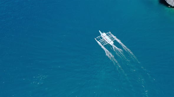 Aerial Drone View of Boat Moving in Open Sea with Clear and Turquoise Water on Sunny Day