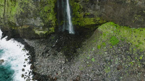 Drone tilt-up reveal of cascading Veu da Noiva waterfall on precipitous cliff