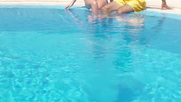 Young couple sitting at poolside