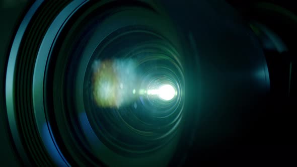 Macro Closeup Shot of Film Projector Activation with Flying Dust and Flare