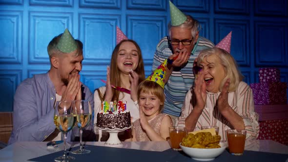 Girl Kid Blowing Candles on Cake Making Wish Having Fun Celebrating Birthday Party with Family