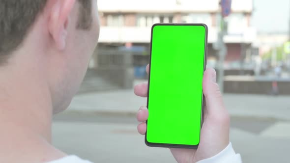 Close Up of Young Man Using Smartphone with Green Screen Outdoor