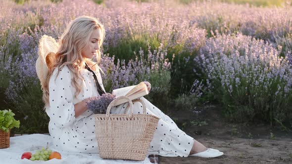 Pretty Blond Woman in a Dress Sitting in the Lavender Field