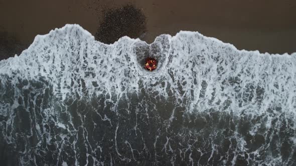 Aerial View From Above on Old Rusty Floating Marine Mine on the Beach and Volcanic Rocky Shores