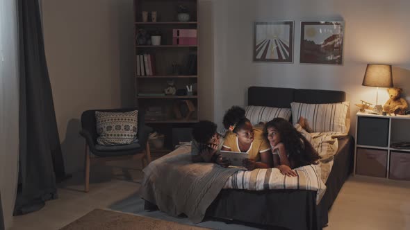 Young Aunt Reading to Siblings at Night