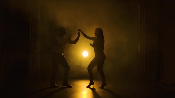 Concept of Social Dance and Relationships. Silhouette of Young Beautiful Couple Dancing Sensual