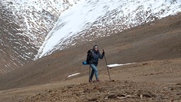 Explorer Female with Backpack Hiking in Mountains