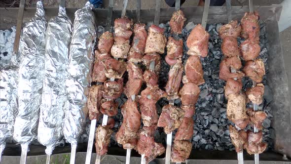 Barbeque on charcoal.  Meat on metal skewers. 
