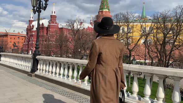 Elegant woman in hat walking on Red Square near Historical Museum, Kremlin, Red Square Moscow Russia