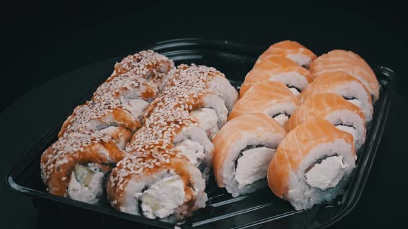 Sushi Rolls Rotating in Plastic Box