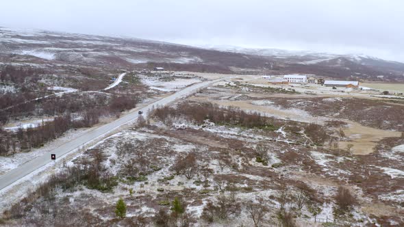 Vehicle Driving Through Dovre Mountains During Winter In Norway - aerial panoramic