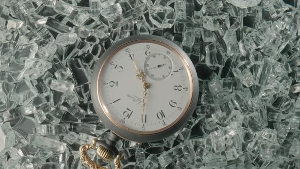 Top View of a Gray Vintage Pocket Watch Lying on Shiny Crystals or Sparkling Glass Splinters