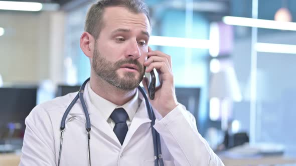 Portrait of Young Doctor Talking on Smartphone in Office