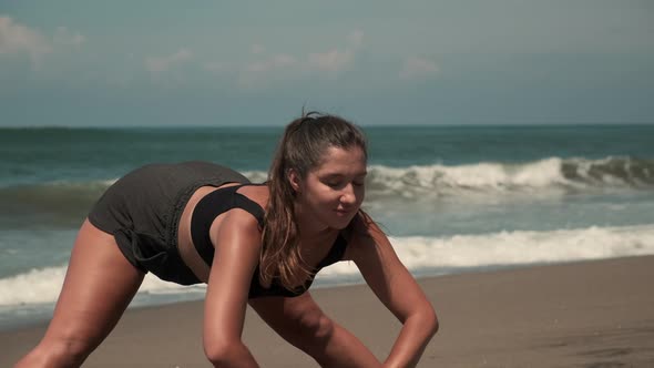 Alluring Lady is Stretching at Sandy Beach of an Ocean