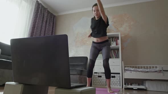 Woman working out in front of laptop