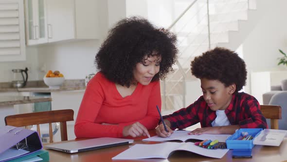 Mother helping son with homework at home