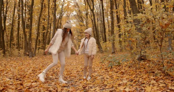 Mother Walking with Preteen Daughter in Autumn Park