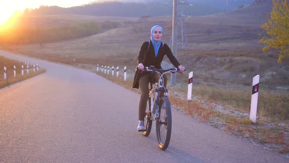 Beautiful Athletic Muslim Woman in Hijab Riding a Bike