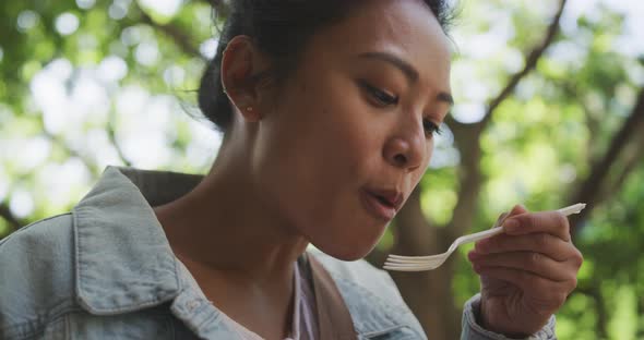 Mixed race woman eating on the street