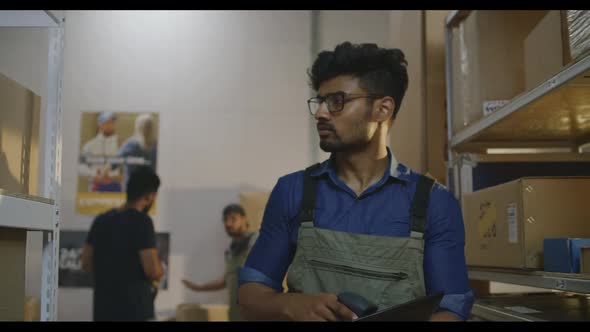 Worker Checking Packages in Warehouse