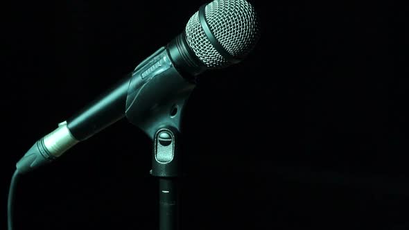 Closeup of Microphone on Stage on Black Background