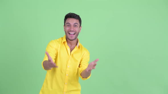 Happy Young Hispanic Businessman with Surprise Gesture