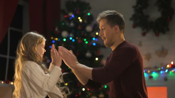 Smiling Father Tickling Little Adorable Daughter on X-Mas Eve, Enjoying Holiday