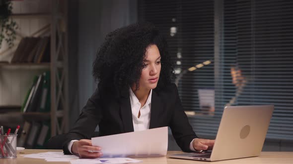 Portrait of African American Woman is Viewing Charts and Graphs Composing Report