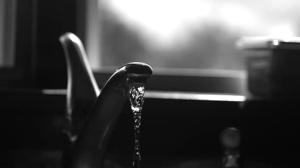 Water pouring from a faucet in ultra slow motion