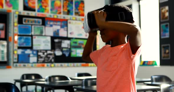 Schoolboy using virtual reality headset in classroom 4k