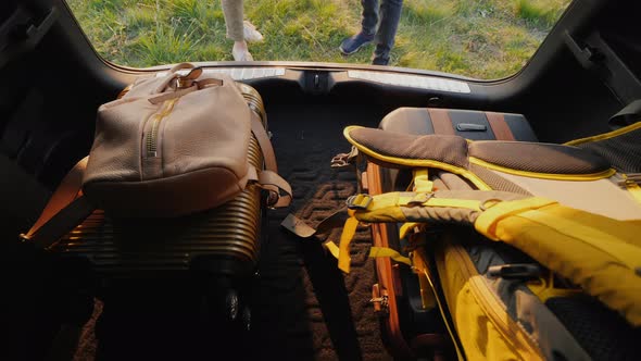 Bags and Backpacks Get Out of the Trunk of the Car