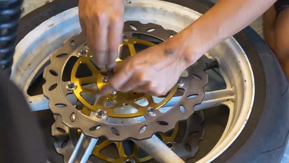 Close-up Footage of Mechanic Working On Disc Brake Installation For Motorcycle