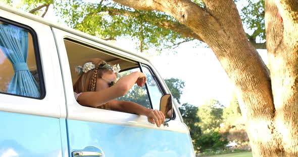Hipster woman looking out of window of the van