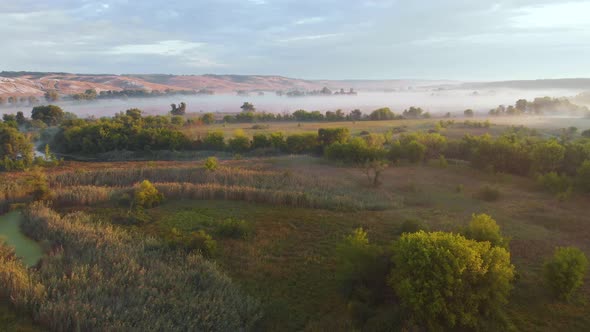 Aerial Drone View of Sunrise Over Misty River