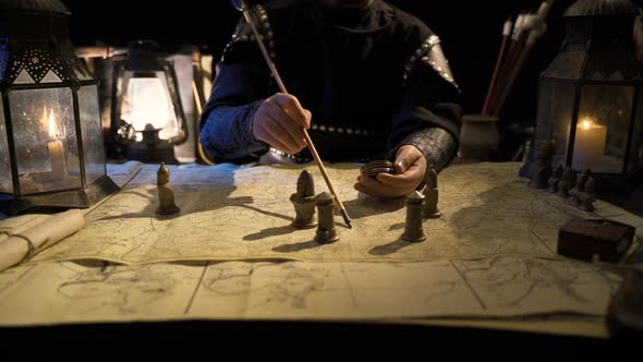 The commander is working on the map with an arrow in his hand.