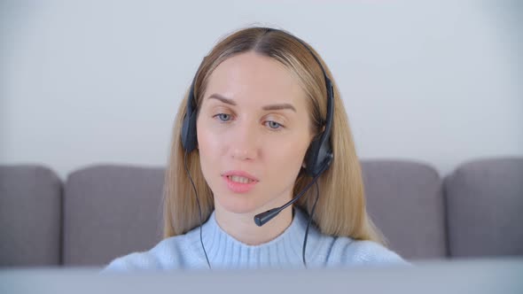 Friendly online support operator in headset speaking on web camera in 4k stock video