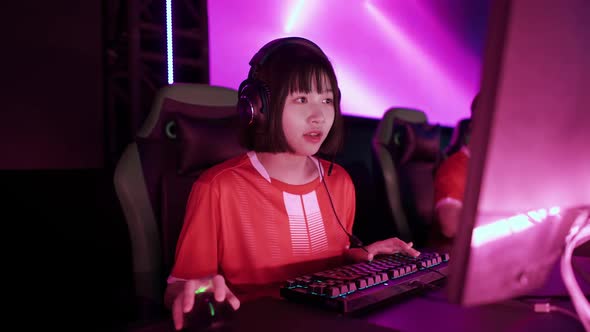 Portrait of a Asian Female Gamer in Headphones Plays a Video Game Cyber Sportsman at the Game