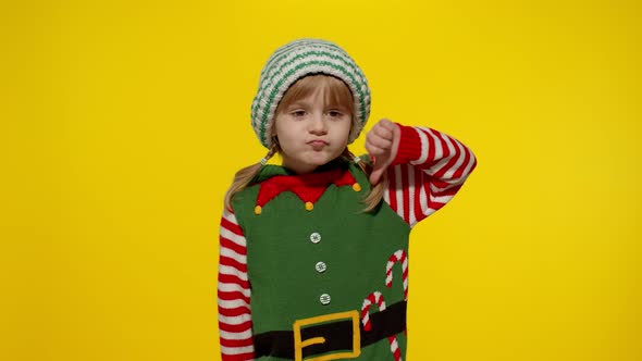 Displesed Kid Girl Christmas Elf Santa Helper Costume Keeps Thumb Down Shows Dislike Gesture