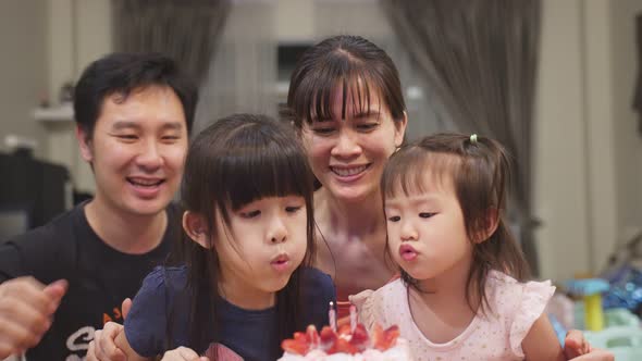 Asian happy young family have birthday party for young little child together at home. Lovely moment.