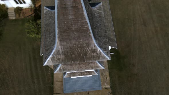 Drone orbiting the single steeple of an old wooden church in north American prairie setting. 4k aeri