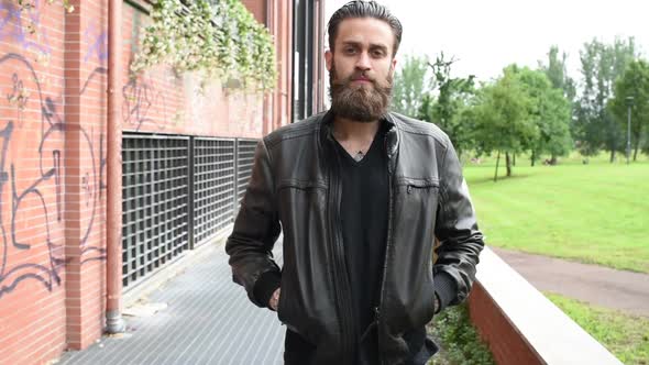 portrait young beautiful bearded man outdoor looking camera hands in pocket
