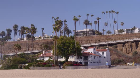 Panning dolly shot of Santa Monica coastline along the famous Pacific Coast Highway.  Cliffside alon