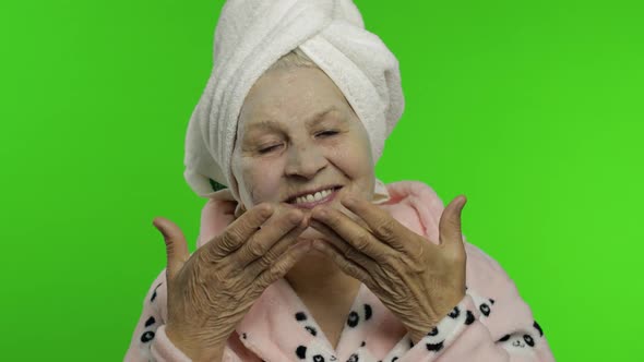 Elderly Grandmother After Shower. Old Woman Applying Cosmetic Bubble Face Mask