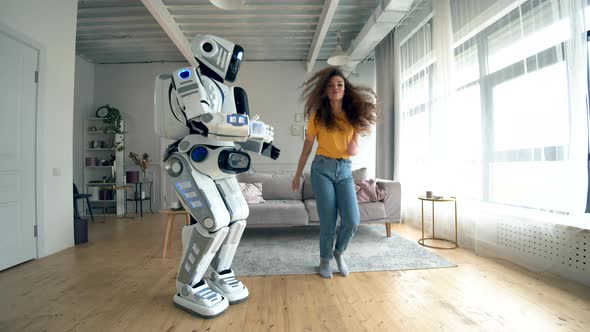 Young Woman and the Robot Are Dancing Joyfully. Robot, Human-like Cyborg Concept.