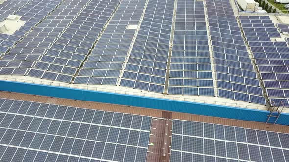 Aerial View of Solar Power Plant with Blue Photovoltaic Panels Mounted of Industrial Building Roof