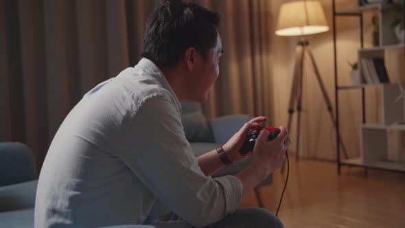 Excited Young Man Gamer Siting On Couch And Playing Video Game