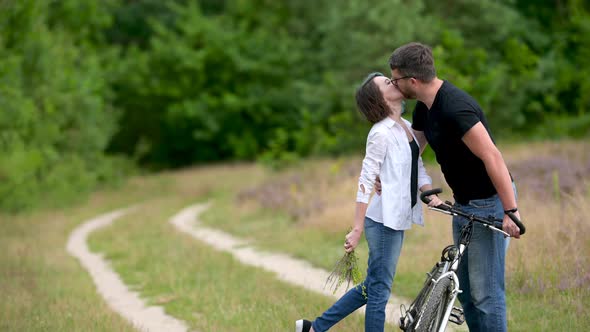 Young happy couple walking holding bicycles in the park