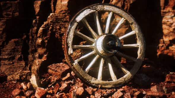 Old Wooden Cart Wheel on Stone Rocks